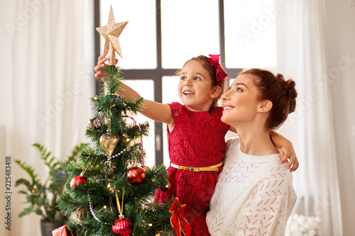 Obraz na plátně family, winter holidays and people concept - happy mother and little daughter de