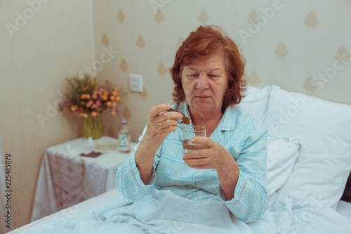 6732083 Lonelly senior woman drinking medecine. photo