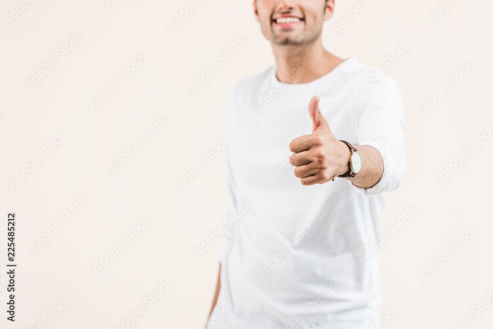 cropped shot of smiling young man showing thumb up isolated on beige cropped shot of smiling young man showing thumb up isolated on beige
