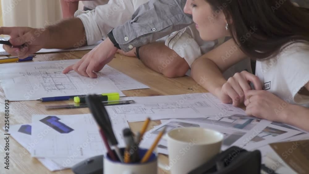 Tired office workers discuss about drawings, architectural drawings Tired office workers discuss about drawings, architectural drawings
