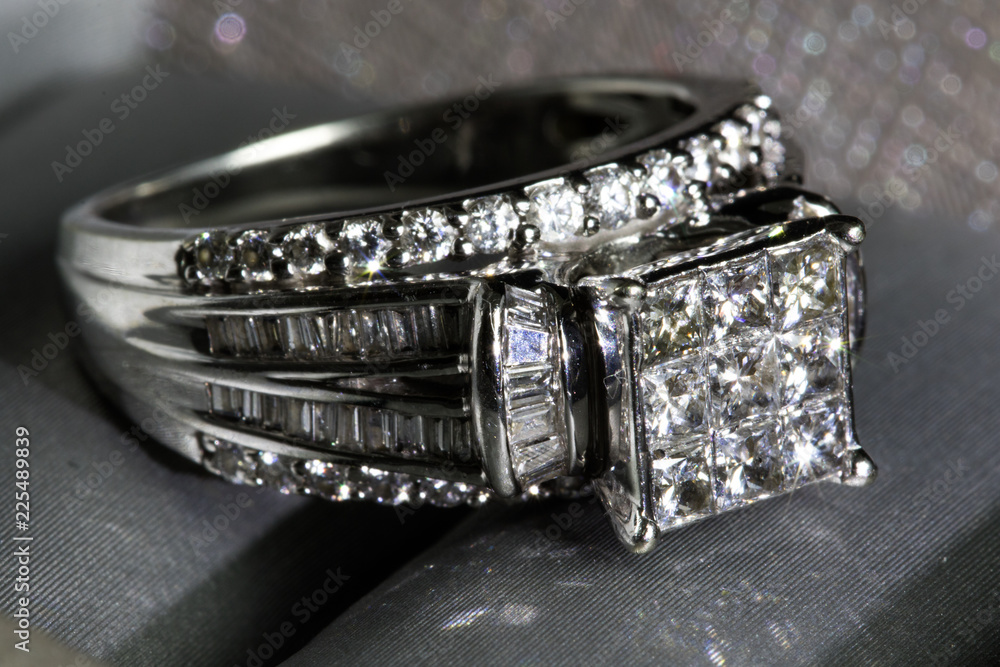 A diamond engagement ring in a box with glint/reflection. Shimmering princess-cut diamonds. A diamond engagement ring in a box with glint/reflection. Shimmering princess-cut diamonds.