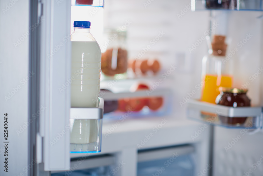 Opened frigde full of groceries. Selective focus on milk. Opened frigde full of groceries. Selective focus on milk.