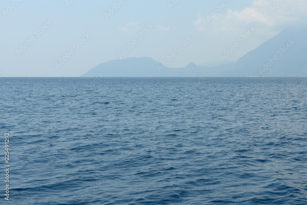 Seascape with the calm sea and an island on horizon (Turkey) Seascape with the calm sea and an island on horizon (Turkey)