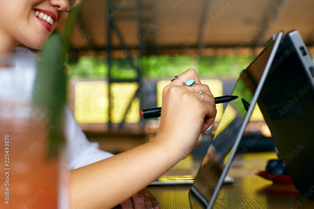 Isolated side view of freelancer woman hand pointing with stylus on  convertible laptop screen in tent