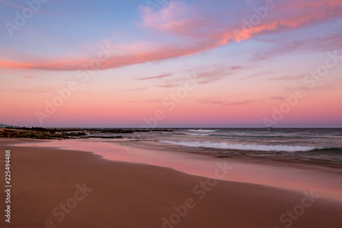 Sunset clouds illuminated in pink at the beach.