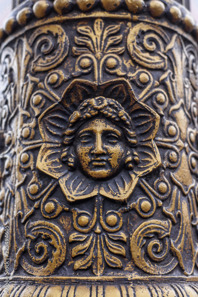 Old metal pillar with human face