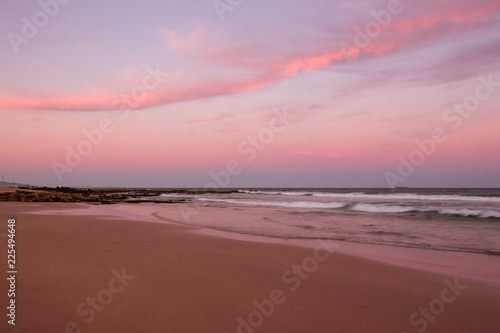 Sunset clouds illuminated in pink at the beach. © Southern Creative