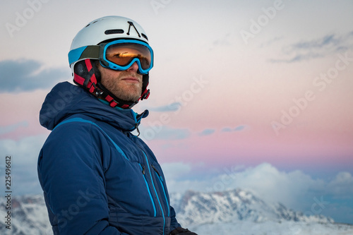 Portrait of a male skier on the mountain at sunset photo