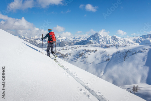 Male ski tourer walking up a summit in the alps © mRGB