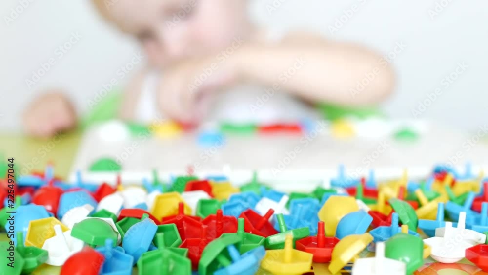 child plays a game of developing motor skills, collect a designer multicolor mosaic for children, development of thinking, learn colors, close-up child plays a game of developing motor skills, collect a designer multicolor mosaic for children, development of thinking, learn colors, close-up