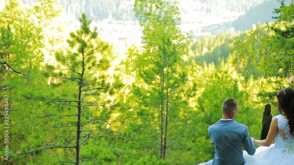 Active couple climbing on the rock in the forest with cliffs, pine trees Active couple climbing on the rock in the forest with cliffs, pine trees