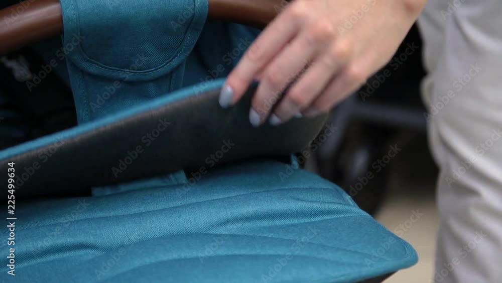 The process of folding a baby stroller in a children's store on the camera. The process of folding a baby stroller in a children's store on the camera.
