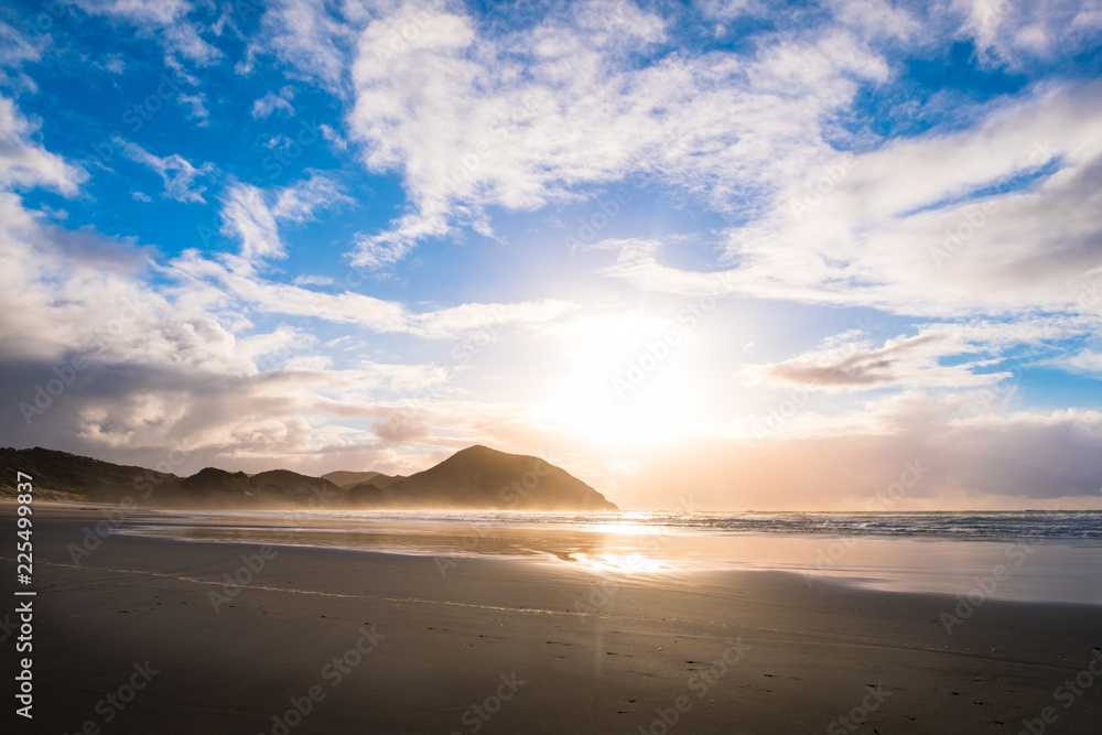 Fototapeta premium The beautiful Wharariki Beach with famous rocks. Sunset scene golden light and silhouette. Nelson, South Island, New Zealand.