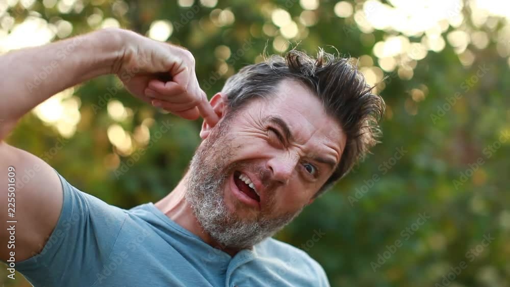 A man is using a finger to clean out his ears. funny video A man is using a finger to clean out his ears. funny video