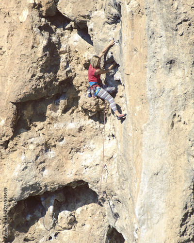Young female rock climber on a cliff face.