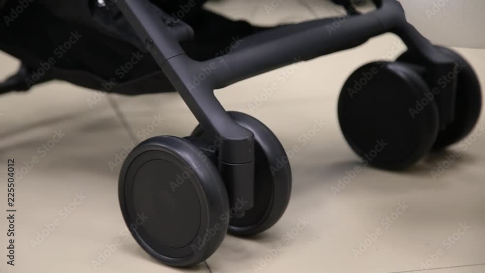 The process of folding a baby stroller in a children's store on the camera.