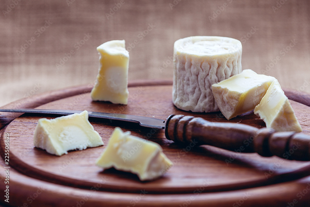 goat cheese on a wooden Board in the gentle daylight on a rag background goat cheese on a wooden Board in the gentle daylight on a rag background