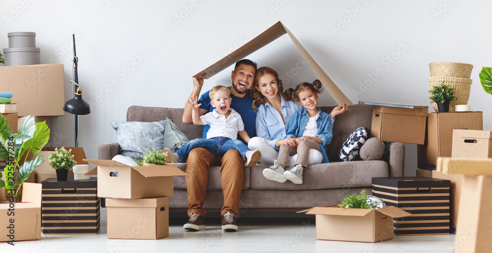 Fototapeta premium szczęśliwa rodzina matka ojciec i dzieci przeprowadzają się do nowego mieszkania i rozpakowują pudełka