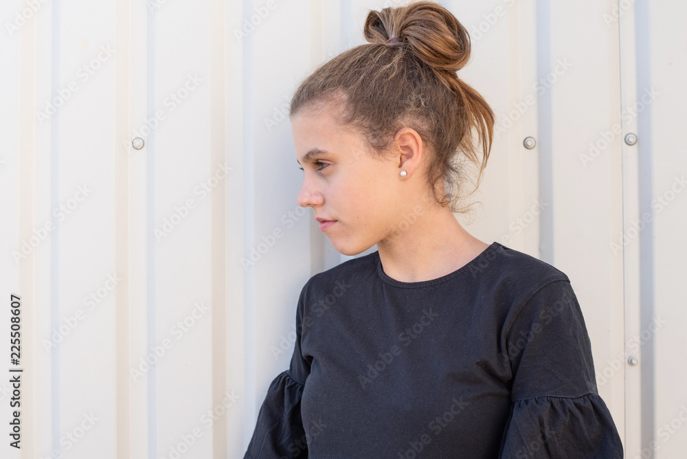 Beautiful teenager is standing in front of white door Beautiful teenager is standing in front of white door