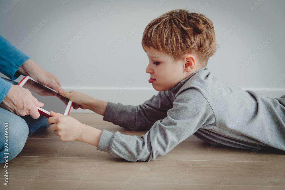 Fototapeta uzależnienie od komputera - ojciec bierze tabliczkę dotykową od gniewnego dziecka