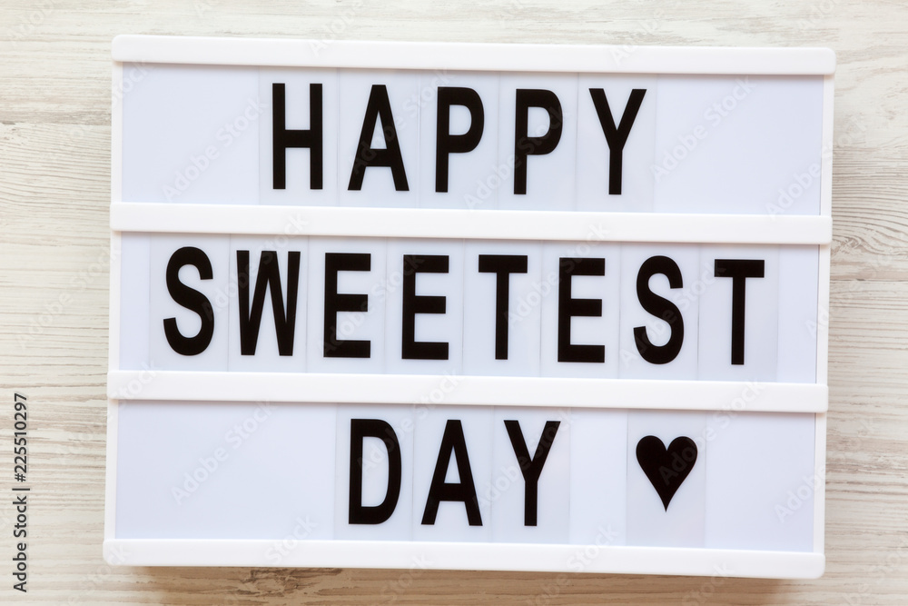 Lightbox with text 'Happy Sweetest Day' word over white wooden background, top view. From above, flat lay, overhead.