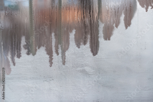 Winter frozen window glass with vertical drips and copy space.