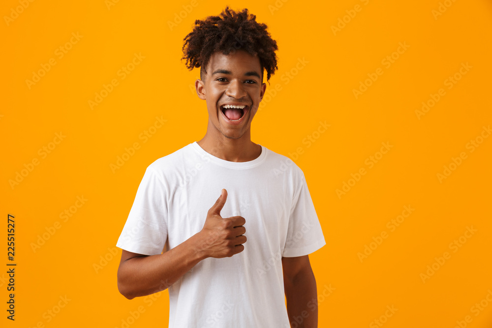Happy young african man posing isolated over yellow background showing thumbs up. Happy young african man posing isolated over yellow background showing thumbs up.