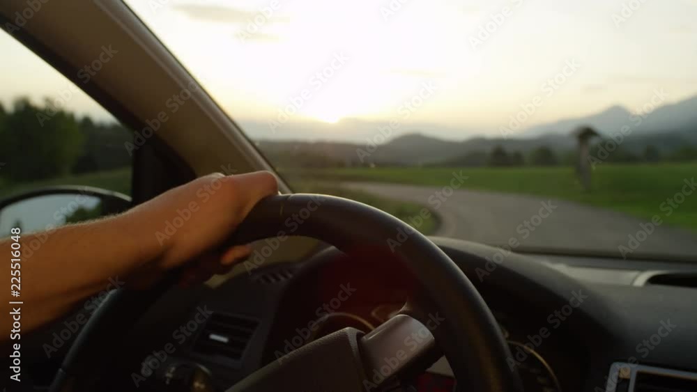 custom made wallpaper toronto digitalSLOW MOTION, CLOSE UP, DOF: Unrecognizable man holds the steering wheel while driving through the scenic countryside at sunset. Cinematic cruise down empty road surrounded by idyllic rural landscape.
