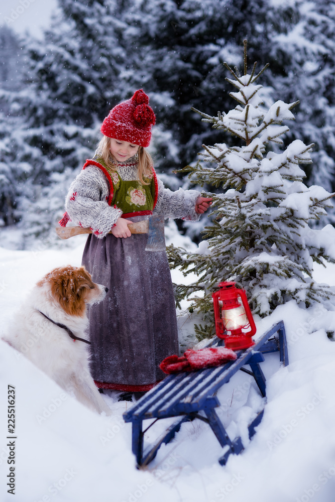 Little girl and her dog finding christmas tree in the forest in deep snow Little girl and her dog finding christmas tree in the forest in deep snow