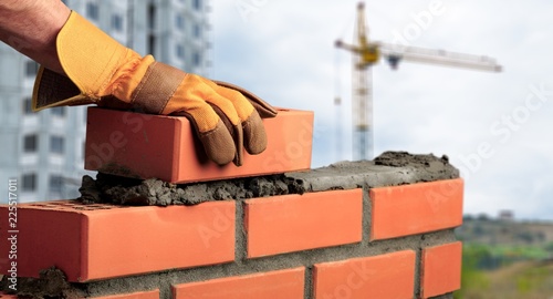 Worker builds a brick wall in the