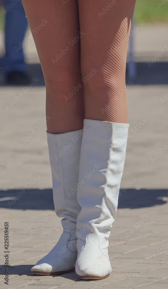 Legs of a girl in white leather boots