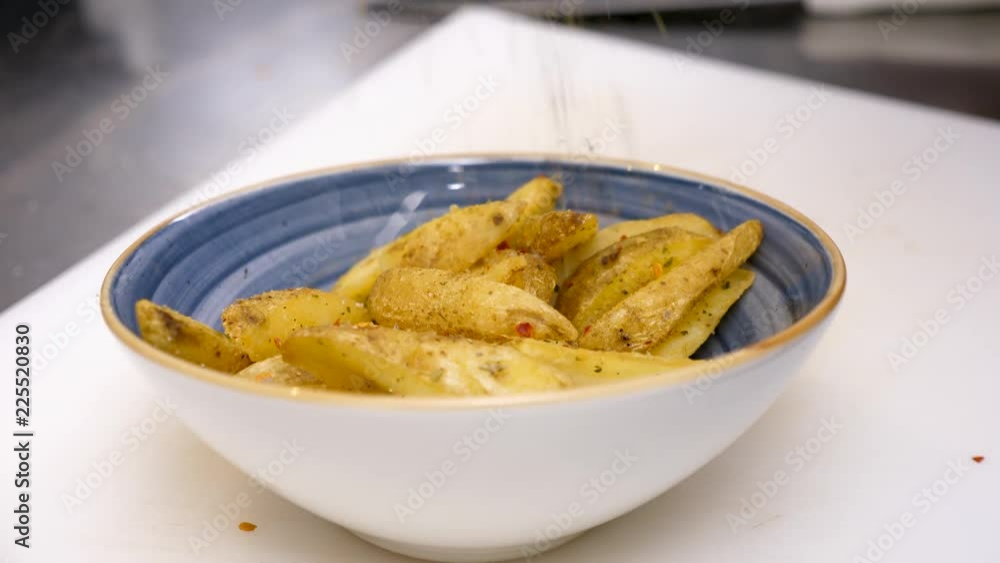 Seasoning fried potatoes in a plate in restaurant. Close up footage Seasoning fried potatoes in a plate in restaurant. Close up footage