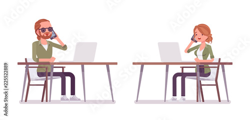 Young red-haired man and woman sitting and working at desk