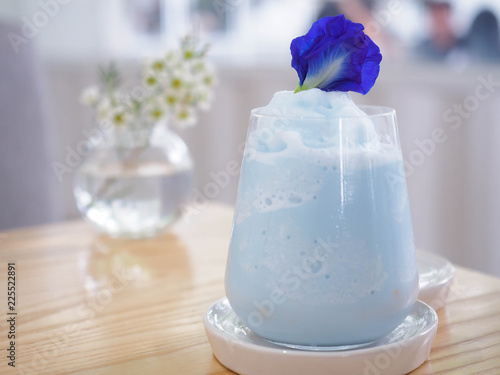 Blue smoothie with pea flower in a cafe. Blue milk shake. Healthy drinking.