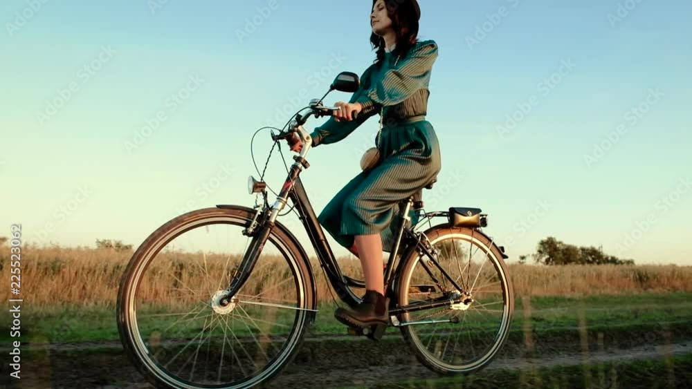 Young girl in a hat and with a bicycle in the steppe. Young girl in a hat and with a bicycle in the steppe.