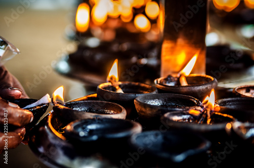 The believer lights a candle in a Buddhist temple. Kalutara. Sri Lanka. 