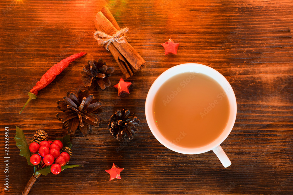 Coffee, spices and pine cones on a wooden background. Christmas concept. A cup of hot coffee with milk, cinnamon and chili on a wooden table. Coffee, spices and pine cones on a wooden background. Christmas concept. A cup of hot coffee with milk, cinnamon and chili on a wooden table.