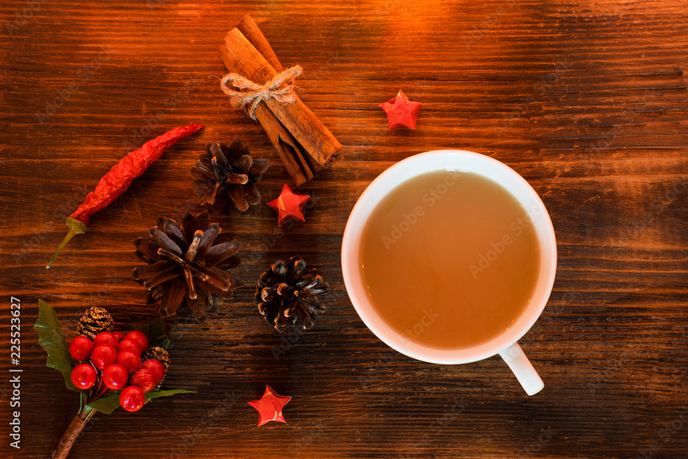 Coffee, spices and pine cones on a wooden background. Christmas concept. A cup of hot coffee with milk, cinnamon and chili on a wooden table. Coffee, spices and pine cones on a wooden background. Christmas concept. A cup of hot coffee with milk, cinnamon and chili on a wooden table.