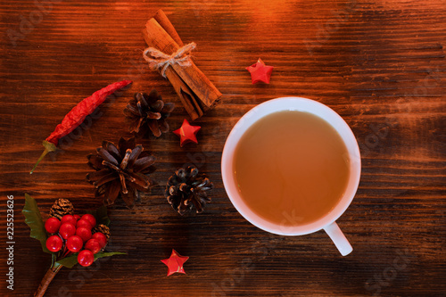 Coffee, spices and pine cones on a wooden background. Christmas concept. A cup of hot coffee with milk, cinnamon and chili on a wooden table.
