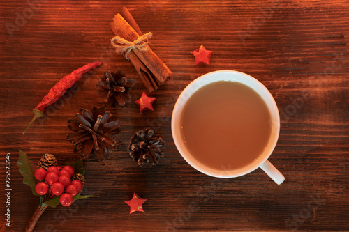 Fototapeta Naklejka Na Ścianę i Meble -  Coffee, spices and pine cones on a wooden background. Christmas concept. A cup of hot coffee with milk, cinnamon and chili on a wooden table.