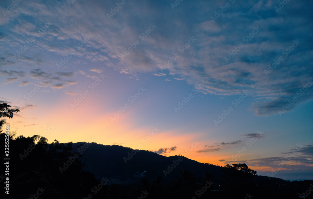 Spectacular sunset over mountains and trees on a tropical island Spectacular sunset over mountains and trees on a tropical island