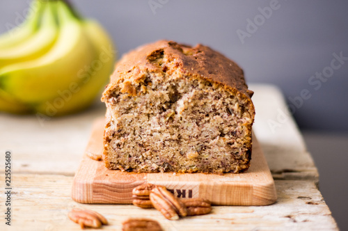 Banana bread loaf with pecans on a wooden table
