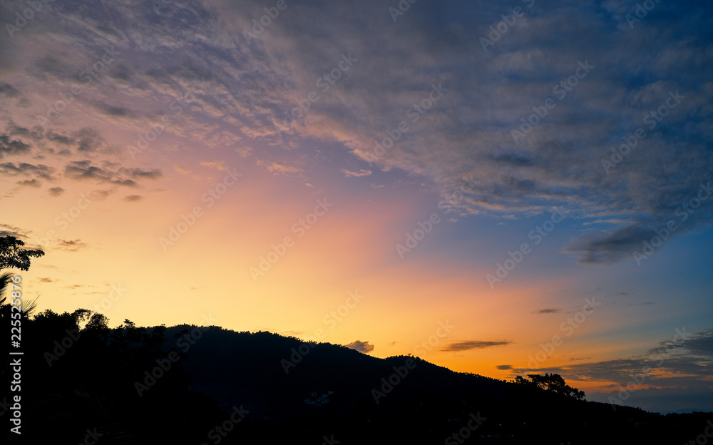 Spectacular sunset over mountains and trees on a tropical island
