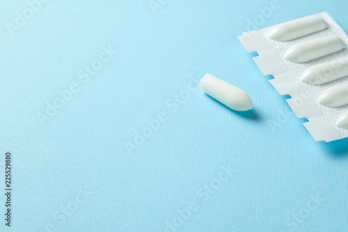 Suppository for anal or vaginal use on a blue background. Candles for treatment of hemorrhoids  temperature  thrush  inflammation