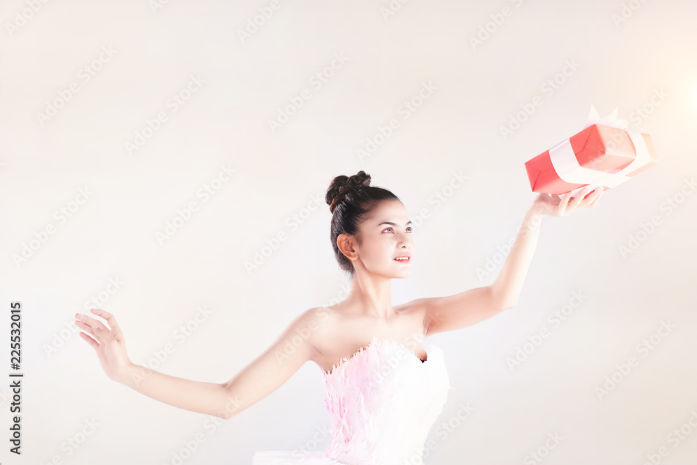 Beauty lady is wearing pink ballet suit,sending gift box up in the air,warm light tone,blurry light cesign background Beauty lady is wearing pink ballet suit,sending gift box up in the air,warm light tone,blurry light cesign background