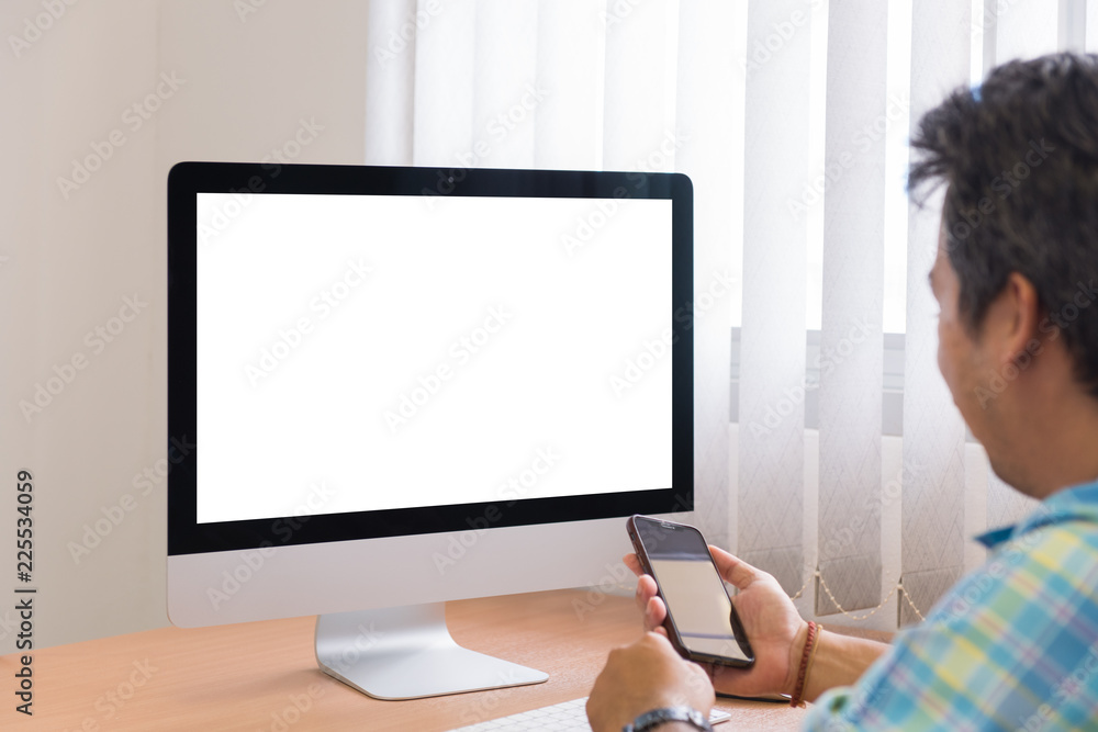 Blank screen of All-in-one computer and smartphone in man's hand Blank screen of All-in-one computer and smartphone in man's hand