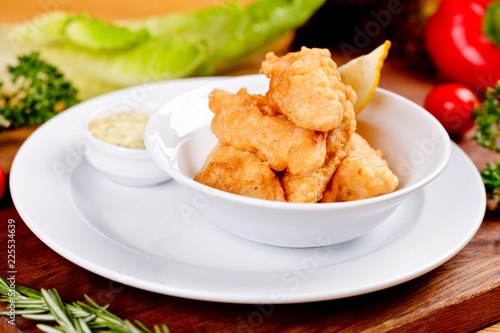 Photography Crispy deep fried fish served with sauce on white plate. Close up