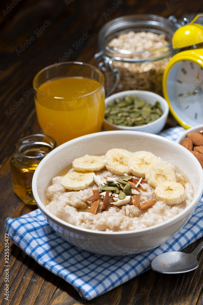 oatmeal with banana, honey and nuts for breakfast, vertical top view