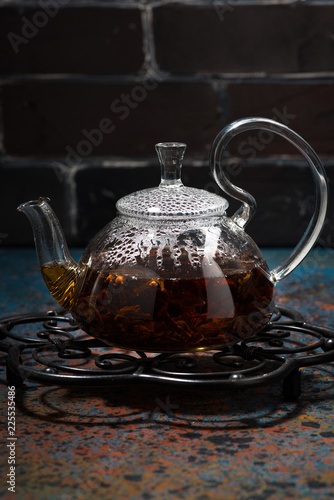 tea masala in a glass teapot on dark background, vertical