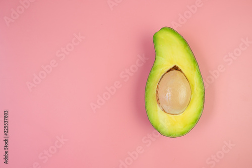 Top view of fresh avocado on pink background with copy space.